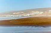 Sandy beach at low tide near village of Taghazout, Morocco, North Africa