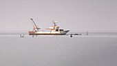 Blick auf ein gestrandetes Fischerboot in Pellestrina in der Lagune von Venedig, Pellestrina, Venetien, Italien, Europa