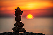 Steinskulptur am Meer bei Sonnenuntergang