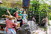Häschenschule und geschmückter Osterbrunnen am Dorfplatz von Ottenhofen in Oberbayern in Deutschland