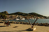 Seepromenade von Port d´Andratx, Paar auf Bank, Skulptur von Carlos Terroba, Blick auf den Hafen und das Tramuntana-Gebirge, Mallorca, Spanien