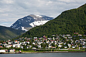 Vorstädtische Wohnhäuser und schneebedeckte Landschaft am Berghang, Tromsø, Norwegen