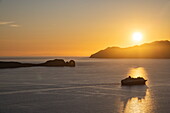 Silhouette des Kreuzfahrtschiffs Celestyal Journey (Celestyal Cruises) und Inseln bei Sonnenuntergang, Plaka, Insel Milos, Kykladen, Südliche Ägäis, Griechenland, Europa