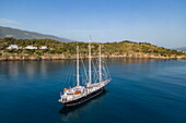  Aerial view of sailing cruise ship &quot;Running on Waves&quot; (M&#39;Ocean) anchored in a bay with coastline, Poros, Attica, Greece, Europe 