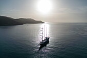  Aerial view silhouette of sailing cruise ship Running on Waves (M&#39;Ocean) anchored in bay at sunrise, Poros, Attica, Greece, Europe 