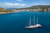  Aerial view of sailing cruise ship Running on Waves (M&#39;Ocean) anchored in a bay with coast and town, Poros, Attica, Greece, Europe 