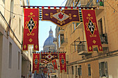 Flags decorate steep historic street in city centre of Valletta, Malta