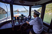  Captain on the bridge of the cruise ship Ginger (Heritage Line) and karst islands, Lan Ha Bay, Haiphong, Vietnam, Asia 