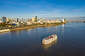  Aerial view of river cruise ship The Jahan (Heritage Line) on the Mekong River in front of the city skyline, Phnom Penh, Phnom Penh, Cambodia, Asia 