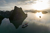 Luftaufnahme des Kreuzfahrtschiffs Ginger (Heritage Line) und Karstinseln in der Bucht bei Sonnenaufgang, Lan Ha Bay, Haiphong, Südchinesisches Meer, Vietnam, Asien