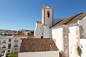 Whitewashed exterior walls and tower of Roman Catholic church Igreja de Santiago, Tavira, Algarve, Portugal, southern Europe