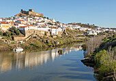 Historisches, von einer Mauer umgebenes mittelalterliches Dorf Mértola mit Burg auf einem Hügel, an den Ufern von Fluss Rio Guadiana, Baixo Alentejo, Portugal, Südeuropa