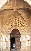 Historic Roman Catholic cathedral church of Évora, Sé de Évora, in the city centre, Basilica Cathedral of Our Lady of Assumption. This image shows details of the carved Gothic period main doorway entrance with carved Apostles either side of the door. The arched ogive or ogival arch is considered a masterpiece of Portuguese Gothic art.