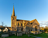Village parish church of Saint Cyriac, Lacock, Wiltshire, England, UK winter evening sunlight