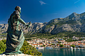  Statue of Saint Peter in front of the city view of Makarska and the Biokovo Mountains, Croatia, Europe  