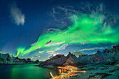  Northern lights over the illuminated village of Mefjordvaer at Mefjord, Mefjordvaer, Senja, Troms, Norway 