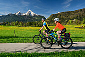 Mann und Frau fahren mit dem Rad am Bodensee-Königssee-Radweg, Watzmann im Hintergrund, Bischofswiesen, Oberbayern, Bayern, Deutschland