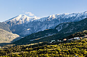 Snow capped peaks including Mount Cika rising above hillside village, Palase, near Dhermi, Albania