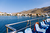  View of the island capital Póthia with customs and port office, nautical museum, town hall (Dimarchio) and pastel-colored houses at the harbor from the ferry boat to the island of Kalymnos (Kalimnos) in Greece 