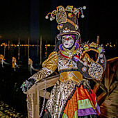  Mask in front of the gondolas at St. Mark&#39;s Square during the Carnival in Venice, Venice, Veneto, Northern Italy, Italy, Europe 