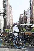  View of canal with bicycles in foreground, Amsterdam, Netherlands 