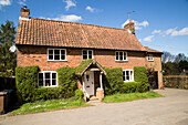 Red brick detached cottage in Shottisham, Suffolk, England, UK