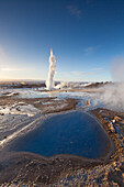  Blesi spring and Strokkur geyser (butter churn geyser) in the Haukadalur hot water valley, winter, Iceland 