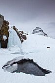  Kirkjufjell mountain with Kirkjufjellsfoss waterfall, winter, Iceland 