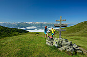  Man and woman hiking on the Pinzgauer Höhenweg take a break at Maureregg, Pinzgauer Höhenweg, Kitzbühel Alps, Salzburg, Austria 