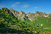  Man and woman hiking with Wurmaulspitze and Eselskopf in the background, Kellerscharte, Pfunderer Höhenweg, Zillertal Alps, South Tyrol, Italy 