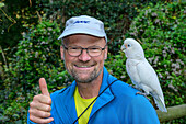  Goffin&#39;s Cockatoo sitting on man&#39;s shoulder, Cacatua goffiniana, Birds of Eden, Plettenberg Bay, Western Cape, South Africa 