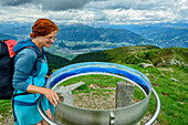  Woman hiking reading labelled mountain panorama on Sambock, Sambock, Pfunderer Höhenweg, Zillertal Alps, South Tyrol, Italy 