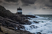  Tour de Vinde lighthouse at the Noirmont lookout point in wind and waves. Rocky coast. 