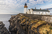  Kirkabister lighthouse stands on a cliff against a blue sky. Shetland 