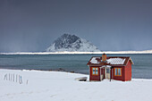  Cabin on snowy fjord, winter, Lofoten, Norway 