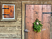  Door of Upper Bavarian wooden hut with fir branch, wintery in Jachenau December 201 