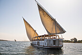 Dahabeah Schiff unter Segeln, Passagier-Flussschiff der Lazuli-Flotte, auf dem Nil bei Sonnenuntergang, bei Assuan, Ägypten, Nordostafrika