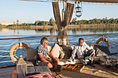 Männer spielen Backgammon am Bug eines Dahabe Bootes, einem Passagierflussboot der Lazuli-Flotte auf dem Nil, Ägypten, Nordostafrika