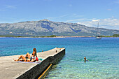 zwei junge Frauen beim Sonnenbaden auf einem Steg, Küste bei Lumbarda, Insel Korcula, bei Dubrovnik, Dalmatien, Kroatien, Südosteuropa