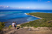 Paar genießt Ausblick über die Lagune und Küste bei Wanderung auf den Berg Le Morne, Le Morne, Rivière Noire, Insel Mauritius, Indischer Ozean