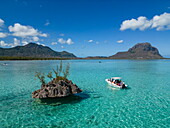 Ausflugsboot in einer Lagune vor Felseninsel mit dem Berg Le Morne, Le Morne, Rivière Noire, Insel Mauritius, Indischer Ozean