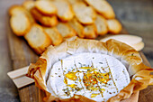 Camembert de Normandie, überbacken mit Honig und Kräutern (Thymian und Rosmarin), serviert in Beuvron-en-Auge im Pays d'Auge im Département Calvados in der Region Normandie in Frankreich