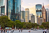 People walk in the Huacheng Square surrounded by modern high-rise buildings. Zhujiang New Town, Tianhe District, Guangzhou, Guangdong Province, China.