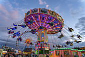 Kettenkarussell beim Oktoberfest in der Abenddämmerung, München, Bayern, Deutschland