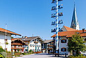 Marktplatz mit historischem Haus Schusterhäusl, Maibaum und Kirche Maria Himmelfahrt in Törwang am Samerberg im Chiemgau in Oberbayern in Deutschland