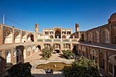 View of the sunken courtyard and the main entrance gate of the 18th century Agha Bozorg Mosque, which also includes a religious school. Kashan, Iran.