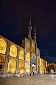 Takyeh (building where Shia Muslims gather to mourn Husayn's death) and minarets of the Amir Chakhmaq Complex illuminated at night. Yazd, Iran.