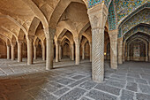  Innenansicht der zentralen Gebetshalle mit vielen Säulen, die das Dach der Backsteingewölbe in der Vakil-Moschee aus dem 18. Jahrhundert in Shiraz, Iran, stützen. 