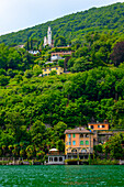 House and Church on Mountainin a Sunny Summer Day on the Waterfront to Lake Lugano in Vico Morcote, Lugano, Ticino, Switzerland.