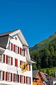 Beautiful Old Town with a Gemeindehaus Community Center House and Mountain in a Sunny Summer Day in Andermatt, Uri, Switzerland.